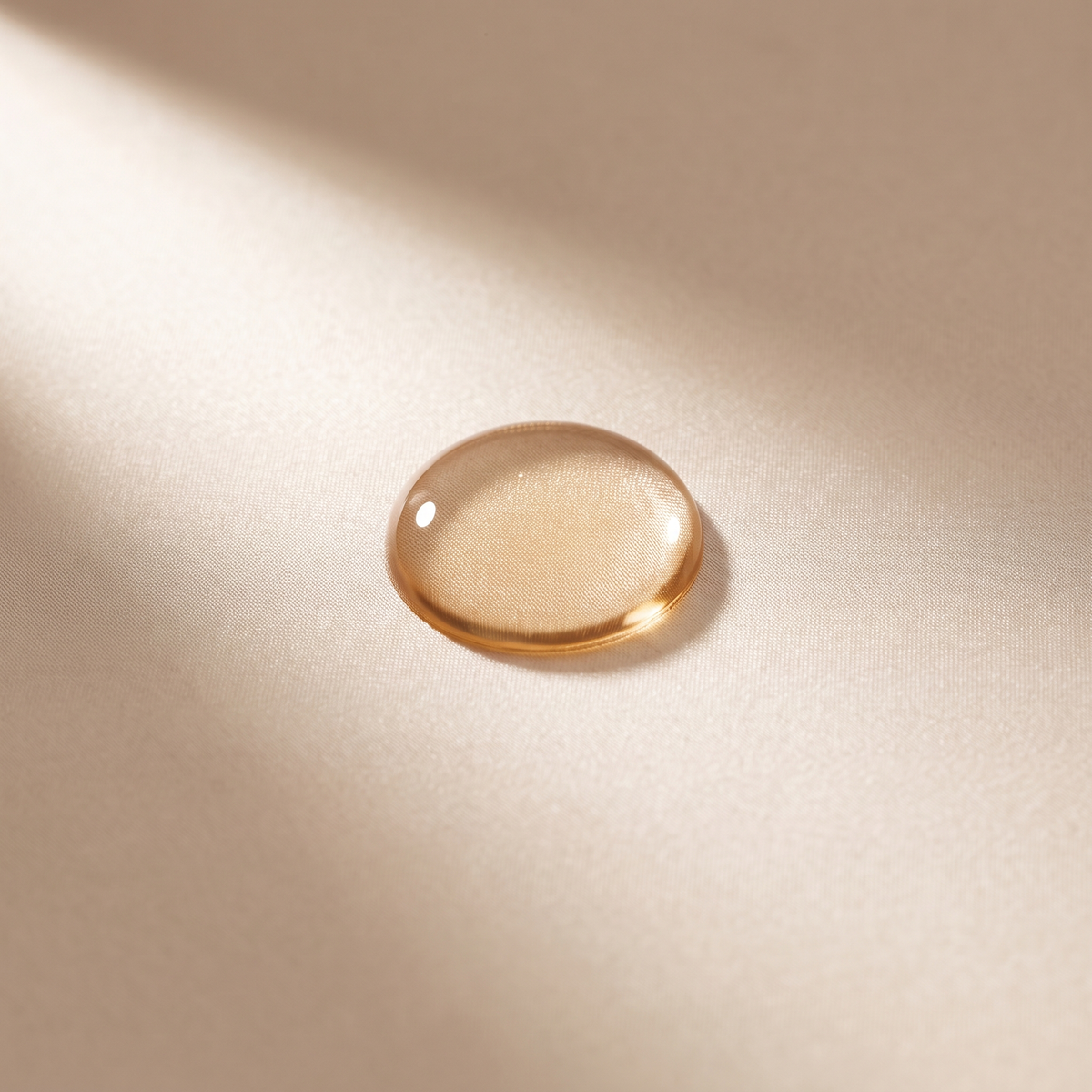La même goutte d'huile sur de la soie de mûrier : elle reste perlée en surface, le tissu est propre.